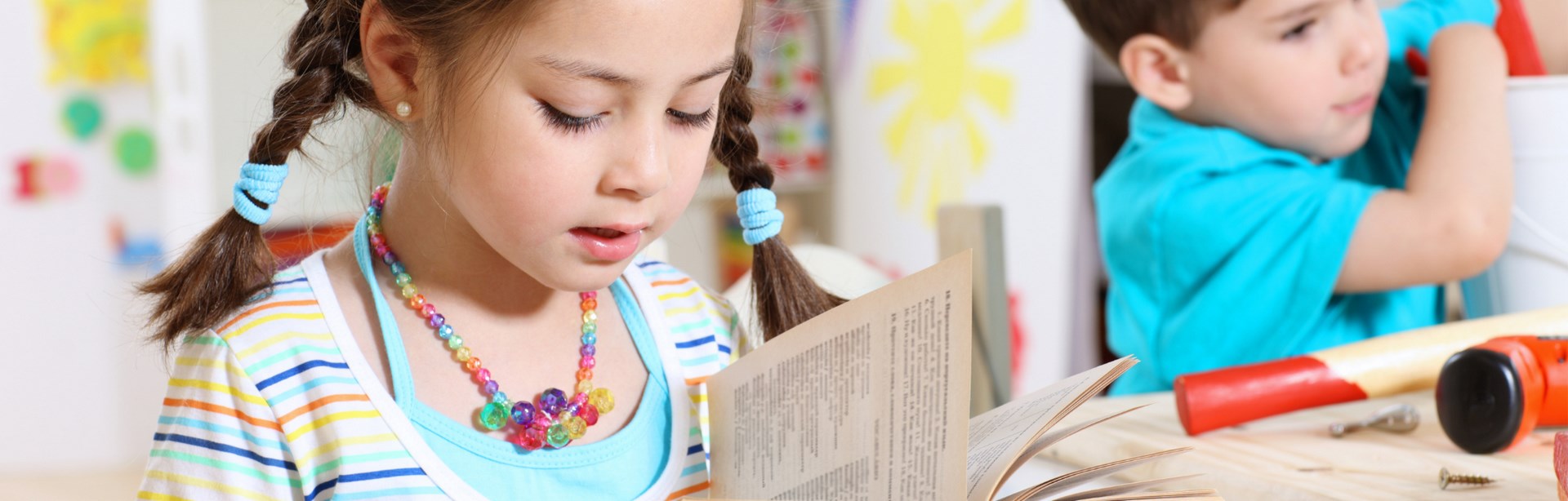 Imagen de portada de curso "Alfabetización Inicial" - Se visualiza una Nena leyendo