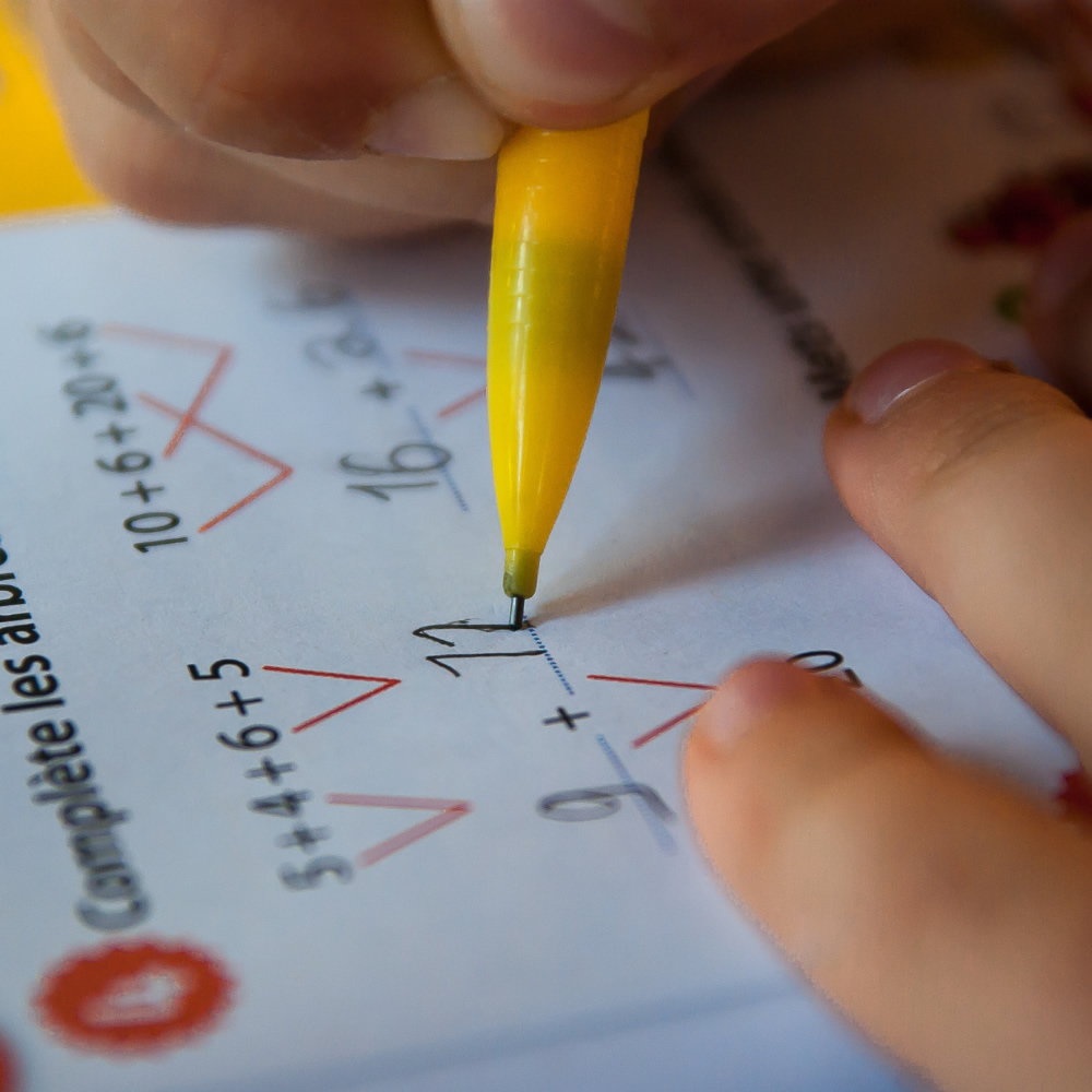 Imagen de portada de curso "Trabajo Matemático" - Se visualiza una persona resolviendo cuentas sobre un papel