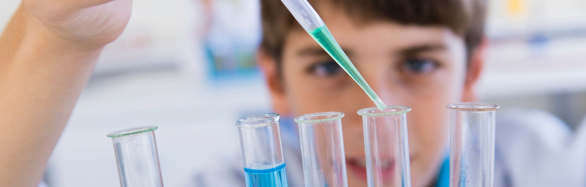 Imagen de portada de curso "Enseñanza por indagación en Ciencias Naturales" - Se visualiza un chico realizando experimentos químicos con tubos de ensayo